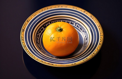 蓝色和黑色条纹碗里的柑橘类水果