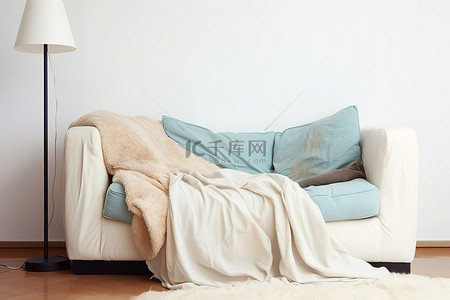 台灯沙发背景图片_白色沙发，配有台灯和毛茸茸的休闲毯