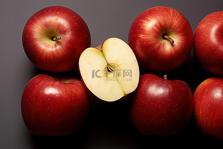 一些红苹果成群结队，其中一个红苹果被切掉了一片