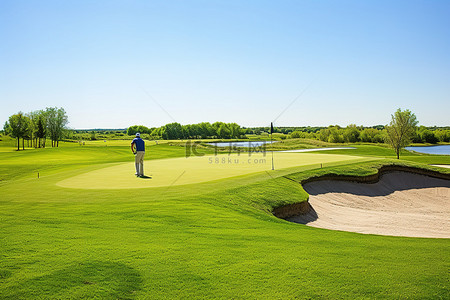 阳光明媚的天空背景图片_阳光明媚的一天，一名高尔夫球手正在高尔夫球场打第 18 洞