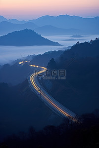 一条高速公路在有雾的背景的山中行驶