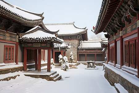 冬天古建筑背景图片_一个小庭院，建筑物被雪覆盖，被雪覆盖