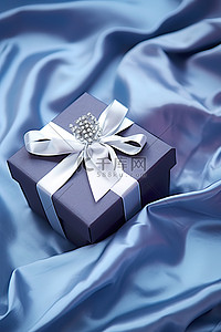 白色圣诞树背景图片_缎面包裹的蓝色和白色礼盒