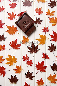白色表面上的秋叶，配有巧克力和房子