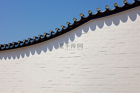 蓝色福背景图片_白色的墙壁上有蓝色和白色的砖块，映衬着天空