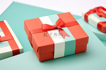 白色表面上一张卡片旁边的两个红色和绿松石色礼盒
