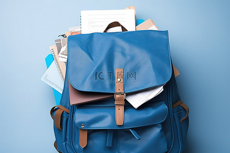 背包画册背景图片_回到书包，上面堆着蓝色皮带和文件