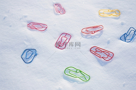 photo浏览器背景图片_彩色回形针躺在雪上 photo