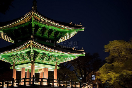 一座宝塔在夜间亮起非常明亮的绿色灯光