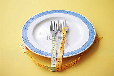 带叉子和勺子的白盘上的大腿测量带