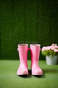 粉红色的雨靴坐在假草前的粉红色桌子上