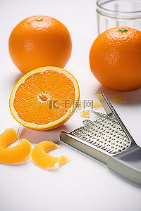 白桌上放着柑橘削皮器和刨丝器的橙片