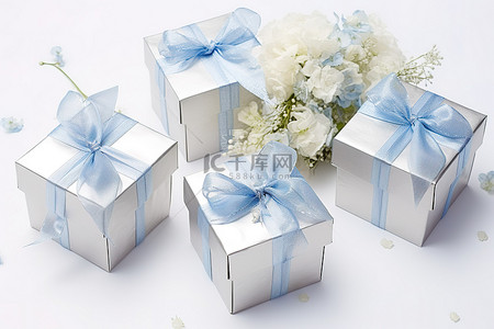 四个银色蓝色盒子，里面装有鲜花和蝴蝶结