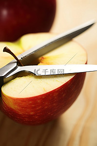 刀切水果背景图片_桌子上刀旁边切好的苹果
