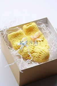 黄色礼物盒子背景图片_一盒碎纸巾里装着黄色的小婴儿袜子