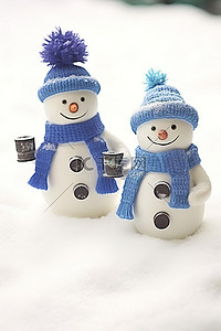 蓝色帽子冬天背景图片_两个戴着蓝色帽子的雪人