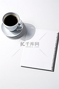 笔记本咖啡背景图片_桌上放着一杯空的白色笔记本咖啡和笔