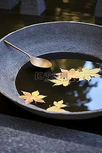 一个带勺子的碗漂浮在圆形混凝土水池上