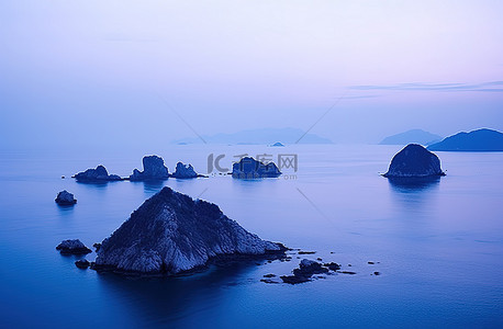 公园的早晨景背景图片_夜晚的岛屿景色，水中有几块蓝色的岩石