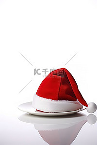 红色的圣诞老人帽子坐在白盘子上