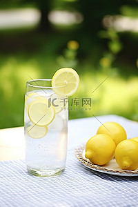 室外背景图片_室外房间草地上的桌子上放着柠檬水，上面有柠檬片
