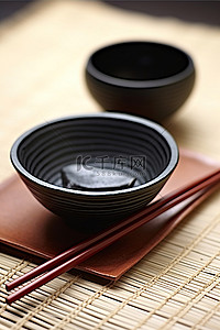 黑色的碗，盘子上有两根筷子