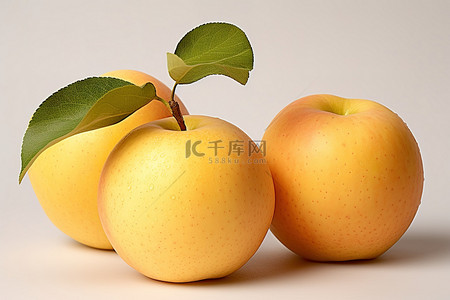 水果苹果树背景图片_三个黄色的苹果，上面长着一棵苹果树