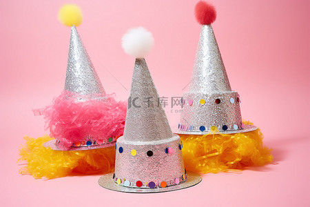 生日蛋糕通用劵背景图片_三顶闪闪发光的帽子和一张卡片位于粉红色的表面上