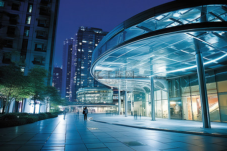 东京日本背景图片_夜晚的城市景观，有通往建筑物的玻璃走道