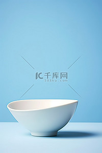 蓝色背景上的单个白色碗和碟子