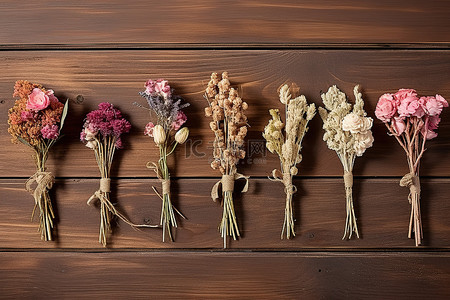 五朵干花在木桌旁边排成一排