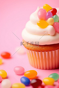 粉红色背景中的香草磨砂纸杯蛋糕，配有果冻豆和大果冻豆