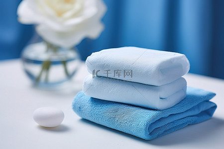 毛巾花背景图片_一堆带蓝色肥皂和蓝色花的白毛巾