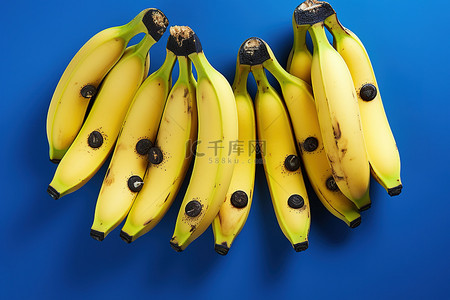 水果生鲜商品背景图片_蓝色背景中的许多黄色香蕉
