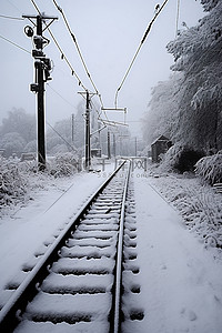 冬天雪景和人背景图片_一组铁轨被雪和电线杆覆盖