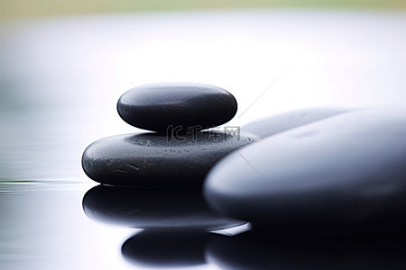 天降福利背景图片_一块黑色石头位于两块黑色石头中间