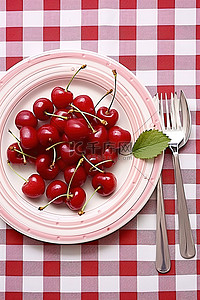 红白格子桌布上放着一盘樱桃
