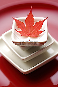 小枫叶背景图片_三个白色小盘子堆在红盘子上，上面有红枫叶