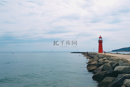 海边码头背景图片_红色灯塔附近的海边