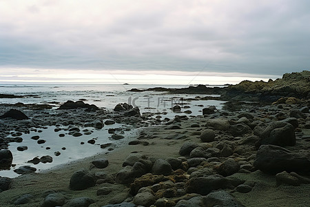 阴天的海背景图片_阴天，海岸上有岩石和石头