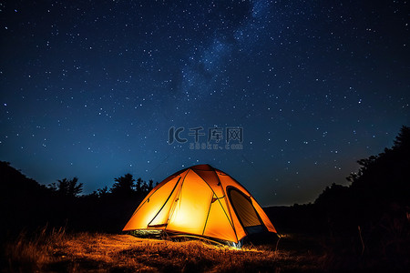夜晚的天空背景图片_夜晚的露营帐篷，顶部有一颗星星