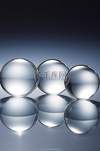 四个透明玻璃球坐在有反射的表面上