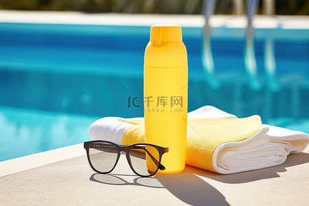 太阳镜背景图片_水瓶太阳镜和泳池旁的蓝色毛巾