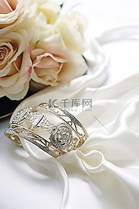 银色玫瑰背景图片_桌上放着玫瑰花束和银色结婚袖口，还有手帕