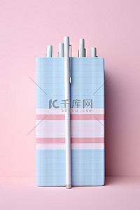 粉色笔记本，内含两支带条纹丝带的笔