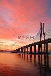 地天空背景图片_一座桥横跨水面，日落时天空美丽