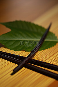 一套筷子和一片叶子，后面有一片黑色的叶子