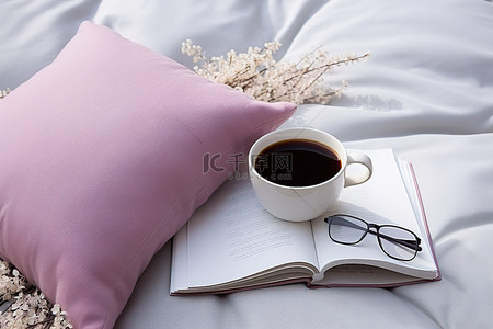 枕头上背景图片_两杯咖啡和一本放在枕头上的书和一条毯子