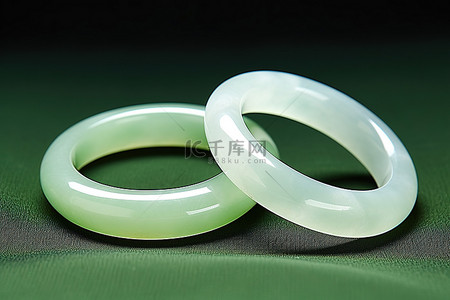 两个戒指背景图片_绿布上有两个玉环