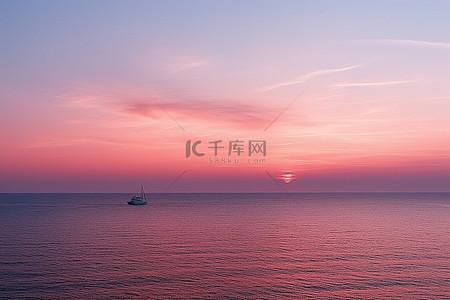 一艘船在水中看到粉红色的夕阳